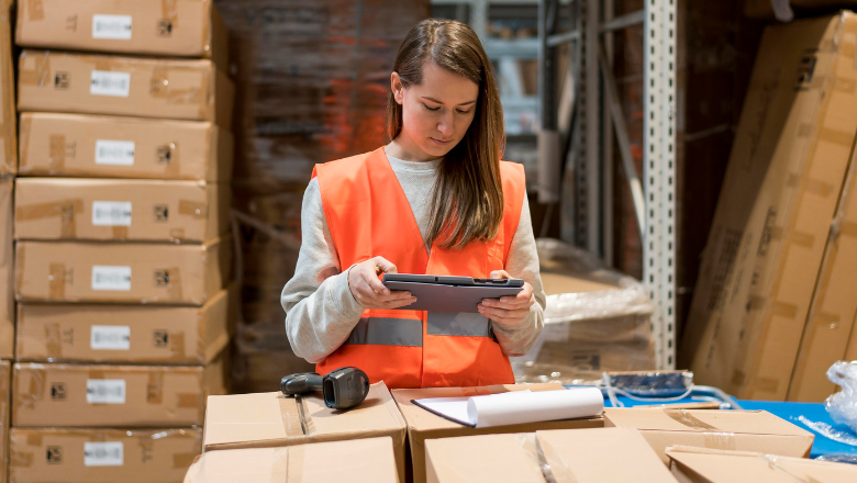 Warenwirtschaft Mitarbeiterin im Lager erfasst Waren mit Tablet – digitale Warenwirtschaft im Einsatz.