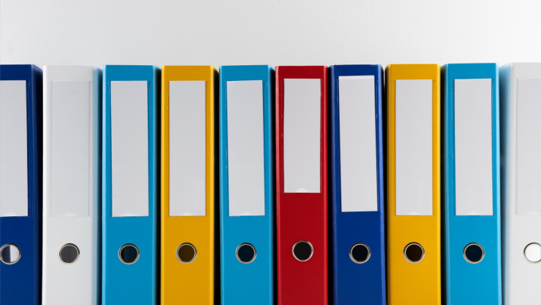 Bunte Ordnerreihe im Regal – steht für strukturierte Archivierung im Rahmen gesetzlicher Aufbewahrungsfristen.