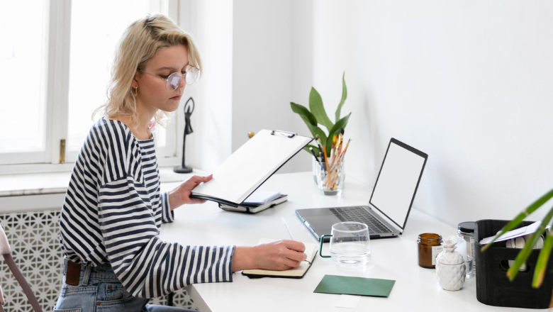 Frau arbeitet am Schreibtisch mit Unterlagen und Laptop – symbolisiert die einfache Abrechnung mit der Betriebsausgabenpauschale.