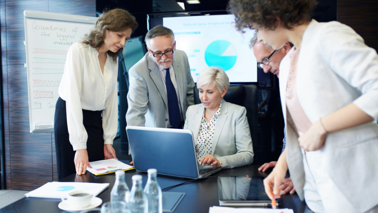 Business-Team bespricht sich vor Laptop und Diagramm – steht für strategisches Enterprise Resource Planning (ERP) im Unternehmen.