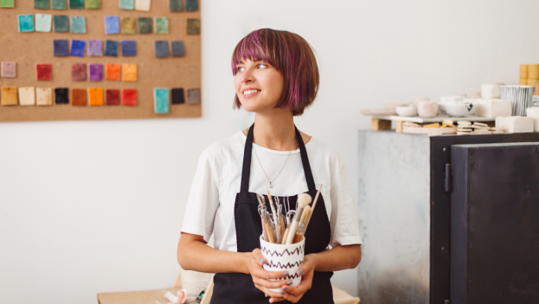 Kleinunternehmerregelung Jungunternehmerin im Atelier mit Werkzeugen – sinnbildlich für GründerInnen, die von der Kleinunternehmerregelung profitieren.