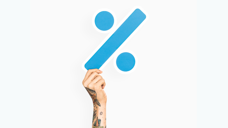 Hand hält ein großes Prozentzeichen als Symbol für die Umsatzsteuer (Mehrwertsteuer)