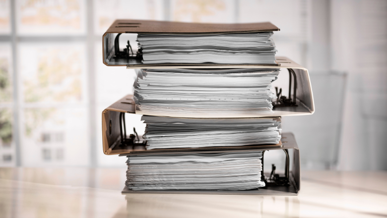 Stapel voller Aktenordner – klassischer Papierkram als Gegensatz zu modernem Dokumentenmanagement (DMS).